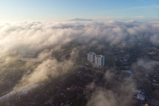 Aerial view of sea of clouds above Alor Setar town with Gunung Jerai on the far background