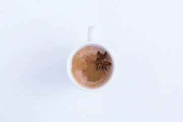 Cocoa drink in the white cup on the white background. Top view.