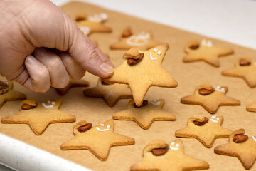 Baked funny star cookies with a nut in a Man's hand. Cookies on the table