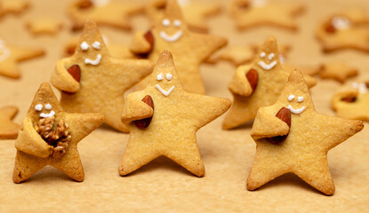 Funny Star cookie with a nut in hand and a face with a smile close-up