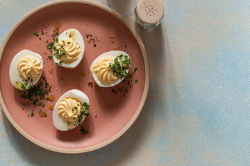 Deviled eggs with fresh herbs and spicy oil, perfect Easter party appetizer, directly above - 750794816