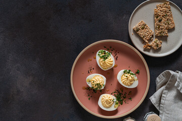 Deviled eggs with fresh herbs, flatbread crackers,  Easter party appetizer, directly above - 750797052