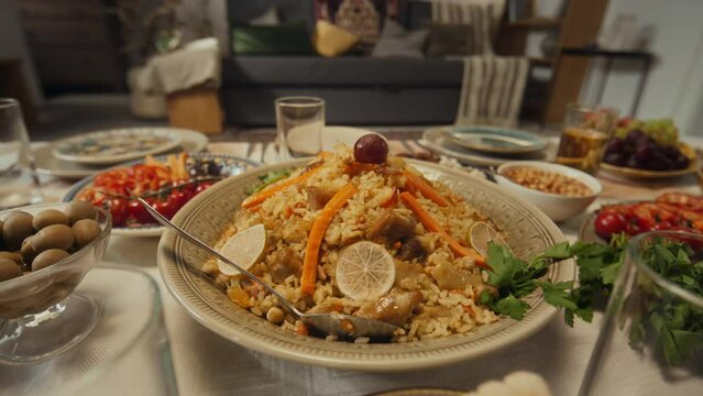 No people closeup of main muslims dish on islamic holiday of Uraza Bayram, pilaf with mutton or beef, carrots, lemon and grapes on festive table at home