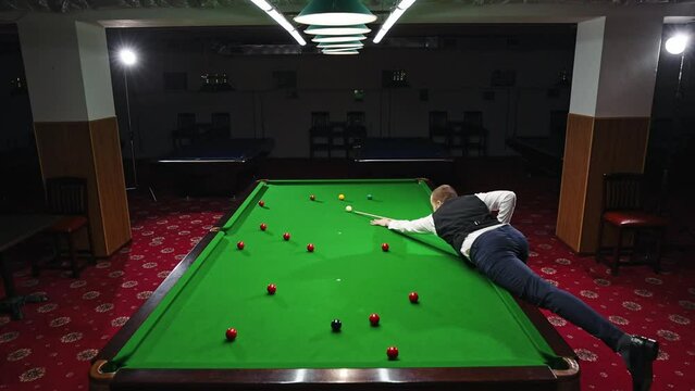 Dynamic shot of a player making shot, expressing energy and excitement for promoting billiards championship and local tournaments. Snooker game. Concept of billiards sport, gambling, hobby, leisure
