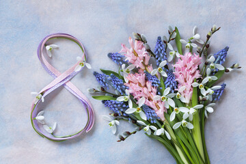 Decorative background with a bouquet of spring flowers of hyacinth, muscari, snowdrops, willow branches and number 8 from ribbon. Beautiful card for Women's Day on March 8th. - 750808897