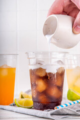 Dirty soda, soda and cream alcohol free mocktail. Iced sweet soda drink with non-dairy creamer,...