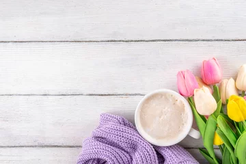 Tuinposter Spring morning with coffee background. A cup of coffee latte, lilac woman knitted sweater, a bouquet of tulips flowers. Spring holidays, holiday background, greeting card, top view flat lay copy space © ricka_kinamoto