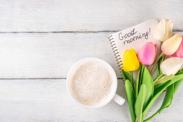 Obraz na płótnie Canvas Spring morning with coffee latte cup background with Good morning note and bouquet of tulips flowers. Spring holidays, holiday background, greeting card, top view flat lay copy space