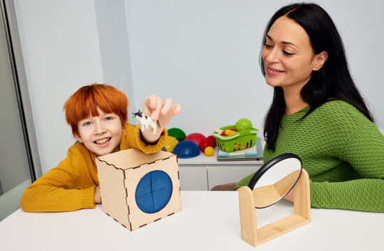 Mental health for kids. Professional kids psychologist working with cute male child in office during play therapy session