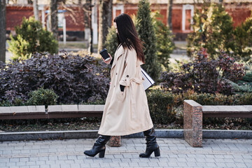 Woman Walking with Coffee and Laptop in Park