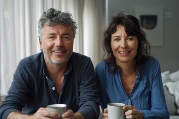 A middle-aged man and woman sit at a table, savoring coffee together