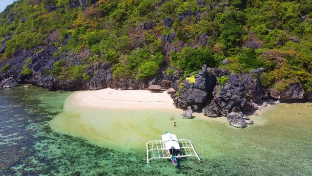 Aerial view 4k drone shot of small islands and beaches around Calauit National park Coron island, the Philippines. Crystal clear turquoise blue waters, palm tree lined white sandy beaches, and visible