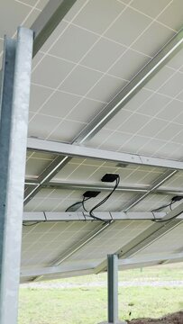 Back side view rows array of polycrystalline silicon solar cells or photovoltaics in solar power plant. Vertical video.