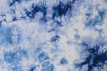 Close-up batik shirt with abstract indigo blue dye detail on white fabric cotton background on top-view