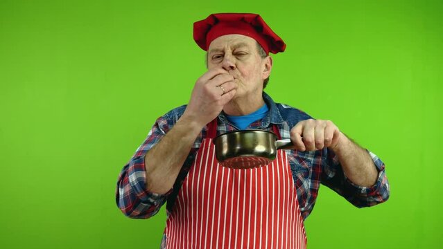 Chef smelling food aroma from stewpan enjoying.