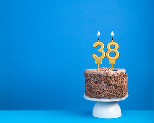 Birthday celebration with candle 38 - Chocolate cake on blue background