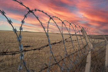metal and electric fences protecting the field.fences protecting the prison. fences that prevent...