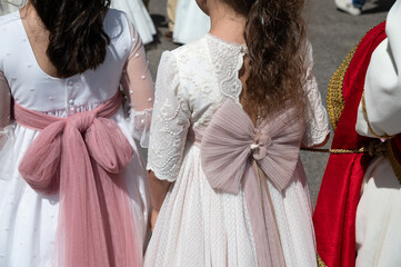 Dos niñas vestidas elegantemente de primera comunión en la procesión del Corpus Christy en España.