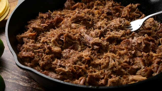 carnitas in skillet pan with tacos ingredients