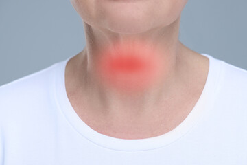 Endocrine system. Woman suffering from pain in thyroid gland on grey background, closeup - obrazy, fototapety, plakaty