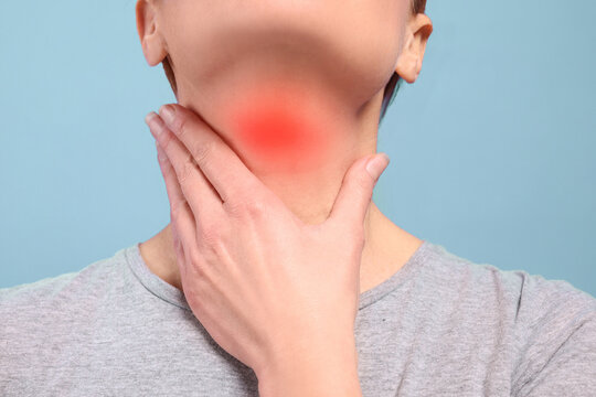 Endocrine system. Woman doing thyroid self examination on light blue background, closeup