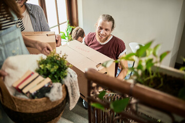 Friends helping each other during a home move carrying boxes