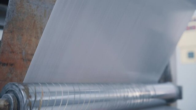 Operation of a flat-slot extruder in the production of polypropylene bags.