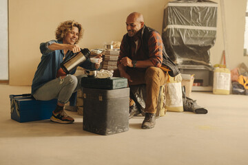 DIY couple resting and smiling during home renovation project