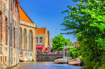 Bakkersrei water canal, Mariabrug bridge and Museum Sint-Janshospitaal building with green trees in...