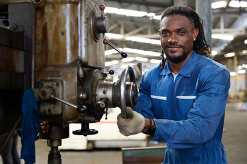 African worker or technician checking and control lathe machine in factory