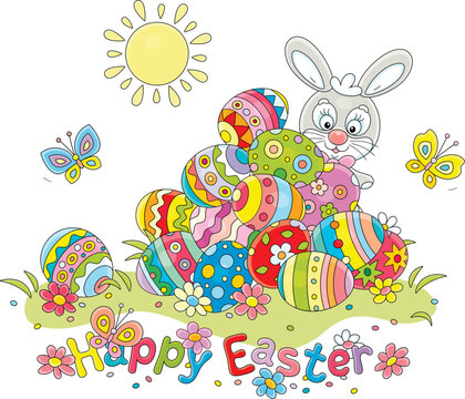 Greeting card with a happy Easter bunny and a pile of colorfully painted gift eggs on a pretty sunny lawn with spring flowers and merry butterflies fluttering around, vector cartoon illustration