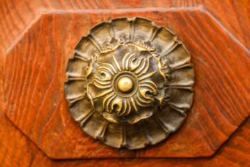 ancient brass doorbell on a brown wooden door
