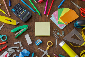 multi colored school and office supplies on wooden background , homeworks flatlay