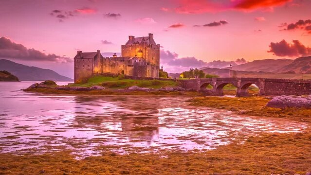 Magenta sunset at Eilean Donan Castle, Dornie, Kyle of Lochalsh in Scotland, United Kingdom. The most visited castle in the UK. Located on an island at the confluence of three sea lochs.