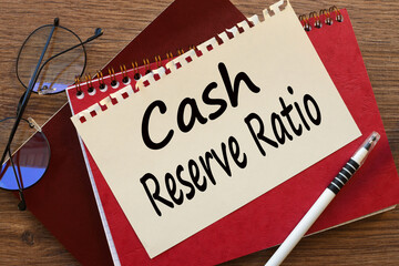 CRR cash reserve ratio text on paper on a red notepad. near the glasses