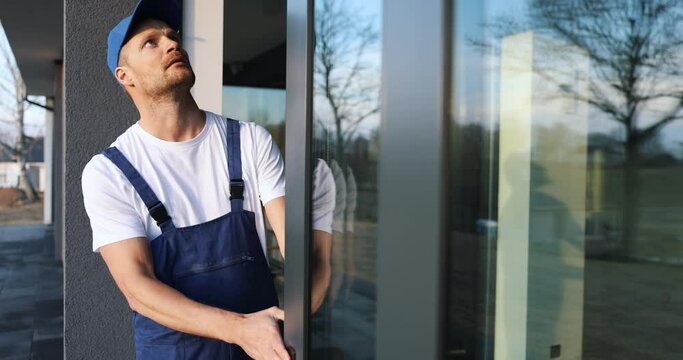 worker installing and adjusting aluminum frame sliding terrace doors