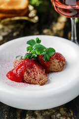 Delicious meat pate foie gras on plate with berry sauce, sprouts and toasts on marble background with drinks. Healthy food, close up