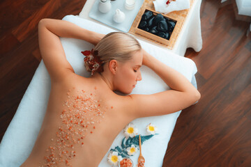 Panorama top view woman customer having exfoliation treatment in luxury spa salon with warmth...