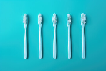 A row of five toothbrushes are lined up on a blue background