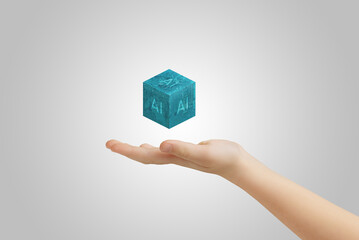 Hand presenting levitating cube with AI text, illustrating artificial intelligence advancements