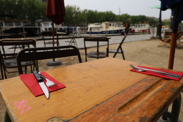 restaurant table and terrace on the Ourcq canal in Paris 19th arrondissement - obrazy, fototapety, plakaty
