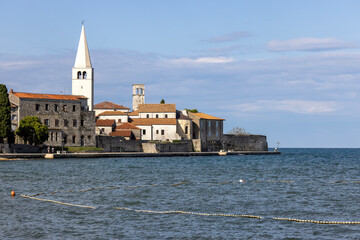 Fototapeta na wymiar View from Nikole Tesle street of seaside with bell tower of Euphrasian Basilica, Porec, Croatia, Istria