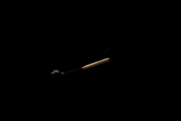 Lit falling match on a black background.