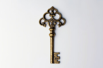 vintage ornate key made of yellow metal, gold or bronze. white background, copy space.
