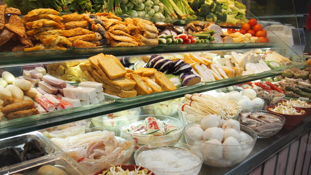 Neatly placed and displayed of Yong Tau Fu or tofu with fish paste; a hawker stall in a hawker center showcasing all the available variety of fishballs and stuffed tofu and vegetables and seafood