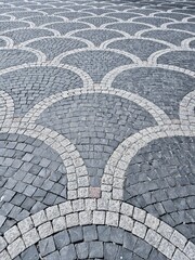 Ornamental cut stone cobblestones laid outdoors in a circular pattern viewed from above as a full frame texture and pattern. © Rattiya