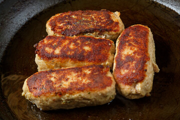Lula cutlets fried in a frying pan with spices in oil.