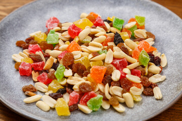 Mix of dried fruits and nuts on a gray plate. Horizontal
