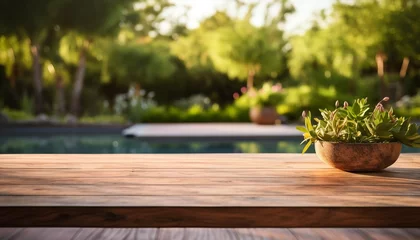 Foto op Canvas Mesa de madera vacía con fondo borroso de jardín y piscina para presentación de producto. © EVF Images