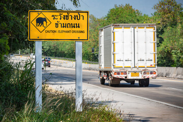 Road metal sign Caution elephants crossing text Caution elephant crossing Thailand countryside